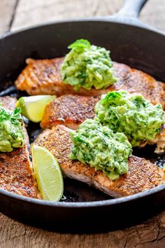 some fish with guacamole and limes in a skillet