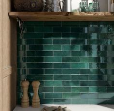 a green tiled backsplash in a kitchen with wooden shelves and white counter tops