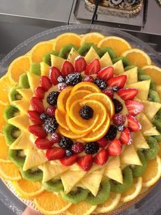 a cake decorated with fruit and sliced oranges