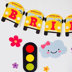 some paper cutouts are sitting on a table next to flowers and a traffic light