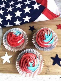 cupcakes with red, white and blue frosting on a wooden cutting board