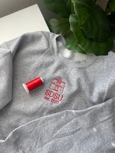 Show your school pride for San Diego State University with this cute minimalistic heather gray crewneck! Want this design on a hoodie instead? Or looking for a different sweatshirt color? Message me, let's make it happen! San Diego Sweatshirt, School Sweatshirt Design Ideas, Cute School Merch, University Hoodie, School Merch Ideas, School Hoodies Design, College Merch Ideas, School Merchandise Ideas, University Merch