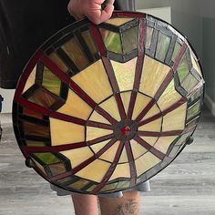 a person holding a stained glass sun catcher