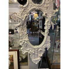 an ornate white mirror is on display in a store