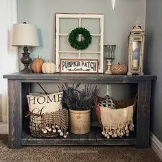 a table with some baskets on top of it next to a lamp and other items