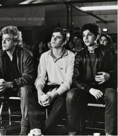 black and white photograph of young men sitting in front of an audience