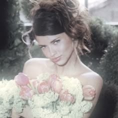 a woman holding a bouquet of flowers in her hands