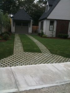 a yard with grass and stepping stones in the middle