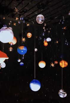 an array of planets hanging from strings in the dark room with stars and other objects