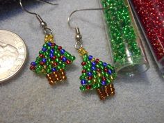 beaded christmas tree earrings next to a penny