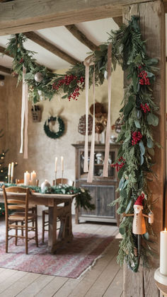 a table with candles and greenery hanging from it's sides in front of a fireplace