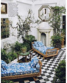 an outdoor living room with couches and potted plants on the tiled flooring