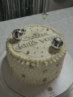 a birthday cake with white frosting and silver decorations