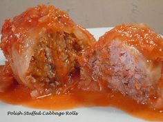 two meatballs covered in sauce on a white plate