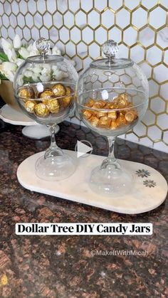 two glass bowls filled with candy on top of a counter