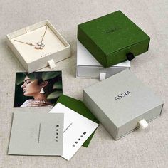 four different boxes with jewelry on them and one box containing an image of a woman's face