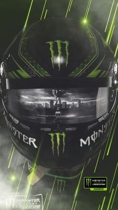 the monster logo is on the back of a motorcycle helmet with green lights behind it