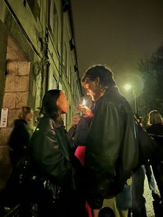 a man and woman standing next to each other holding sparklers in their hands at night