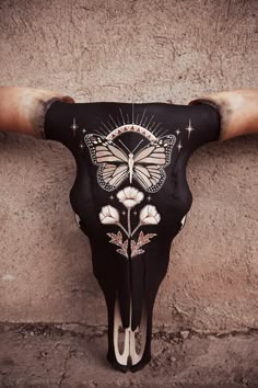 a cow's skull with an intricately painted butterfly on the back of it