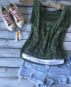 a pair of shorts and sneakers are next to a green tank top