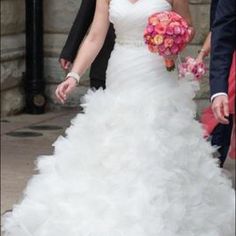 a bride and groom walking down the street