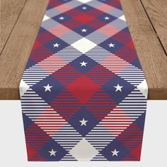 a red, white and blue table runner with stars on it next to a wooden bench