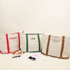 three personalized tote bags sitting on top of a white fur covered floor next to sunglasses