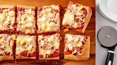 square slices of pizza with cheese and sauce on a cutting board next to a knife