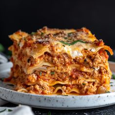 a white plate topped with lasagna covered in meat