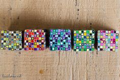 four different colored blocks sitting on top of a wooden table