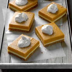 four pieces of dessert sitting on top of a baking sheet covered in icing and marshmallows