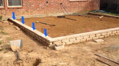 a brick house is being built with blue arrows pointing in different directions to the ground