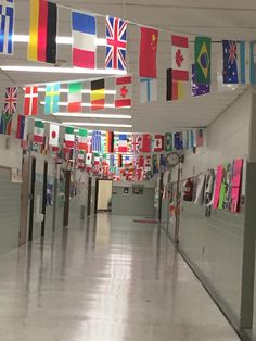 an empty hallway with flags hanging from the ceiling and on the walls in front of them