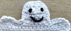 a white crocheted object with a smiling face