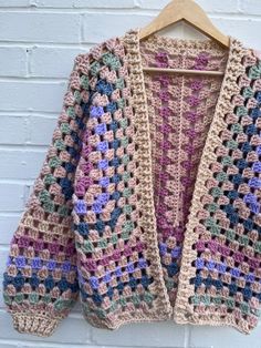 a crocheted jacket hanging on a brick wall