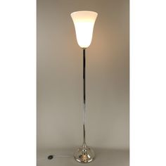 a floor lamp with a white light on it's side and a cord attached to the base