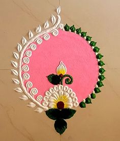 a pink and white clock with green leaves on it's face is hanging from the ceiling