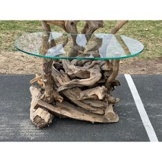 a glass top table made out of driftwood