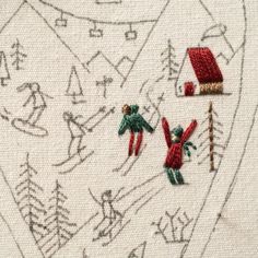 two embroidered red and green christmas decorations on white fabric