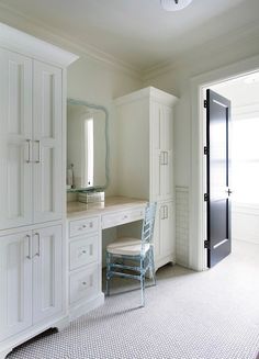 a bedroom with white cabinets and a chair