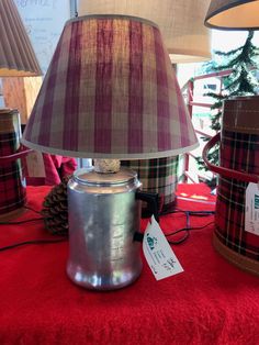 a lamp that is sitting on top of a red table cloth next to other lamps