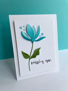 a card with a blue flower on it and the words missing you written in black ink