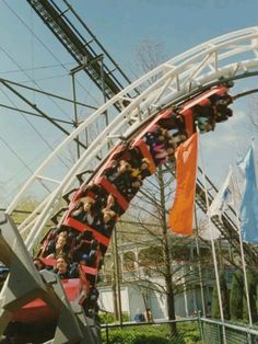 people are riding the roller coaster at an amusement park