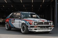 an old race car parked in front of a garage