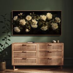 a large painting hanging on the wall above a dresser with drawers and flowers in it