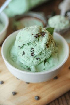 a white bowl filled with ice cream on top of a wooden cutting board