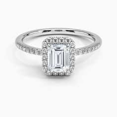 an emerald cut diamond engagement ring with pave set diamonds on the shoulders and sides