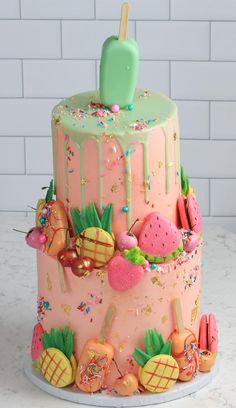 a pink cake with green icing and lots of fruit toppings on the top