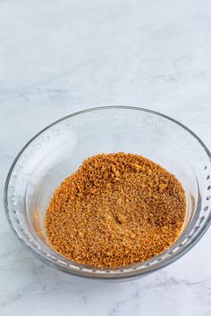 a glass bowl filled with spices on top of a white counter