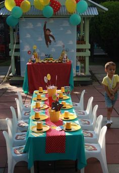 a child's birthday party set up with balloons, plates and cups on the table